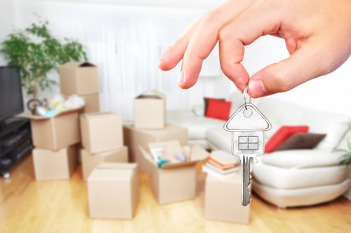 Professional movers carrying furniture through a narrow staircase