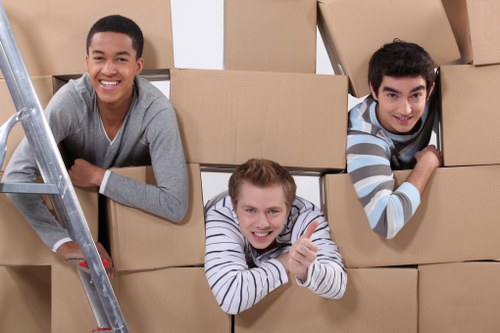 Team carrying furniture through a narrow staircase in South London