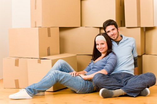 A moving team handling boxes and household items near South London flats